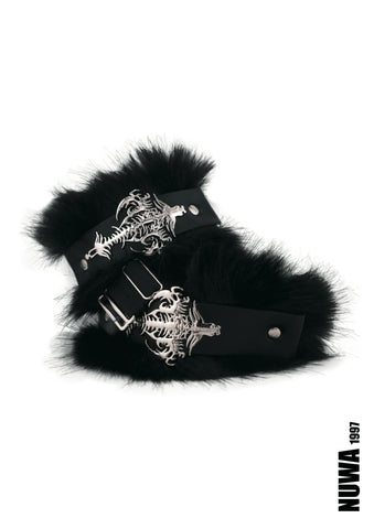 Black faux fur cuffs with silver-toned metal hardware featuring a cross and skeleton design, displayed on a white background with a NUWA 1997 logo in the bottom right corner.