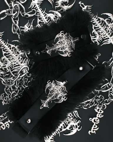 Black faux-fur trimmed choker collar with a black strap and silver gothic skeleton keyhole centerpiece, displayed on a dark background surrounded by matching silver skeleton chain and bone motifs.
